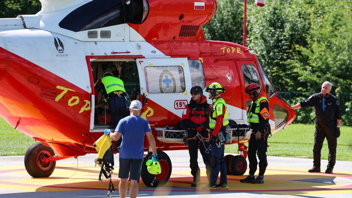 Ratownicy TOPR ładują nosze do śmigłowca, który ma ewakuować partnera zmarłego turysty.