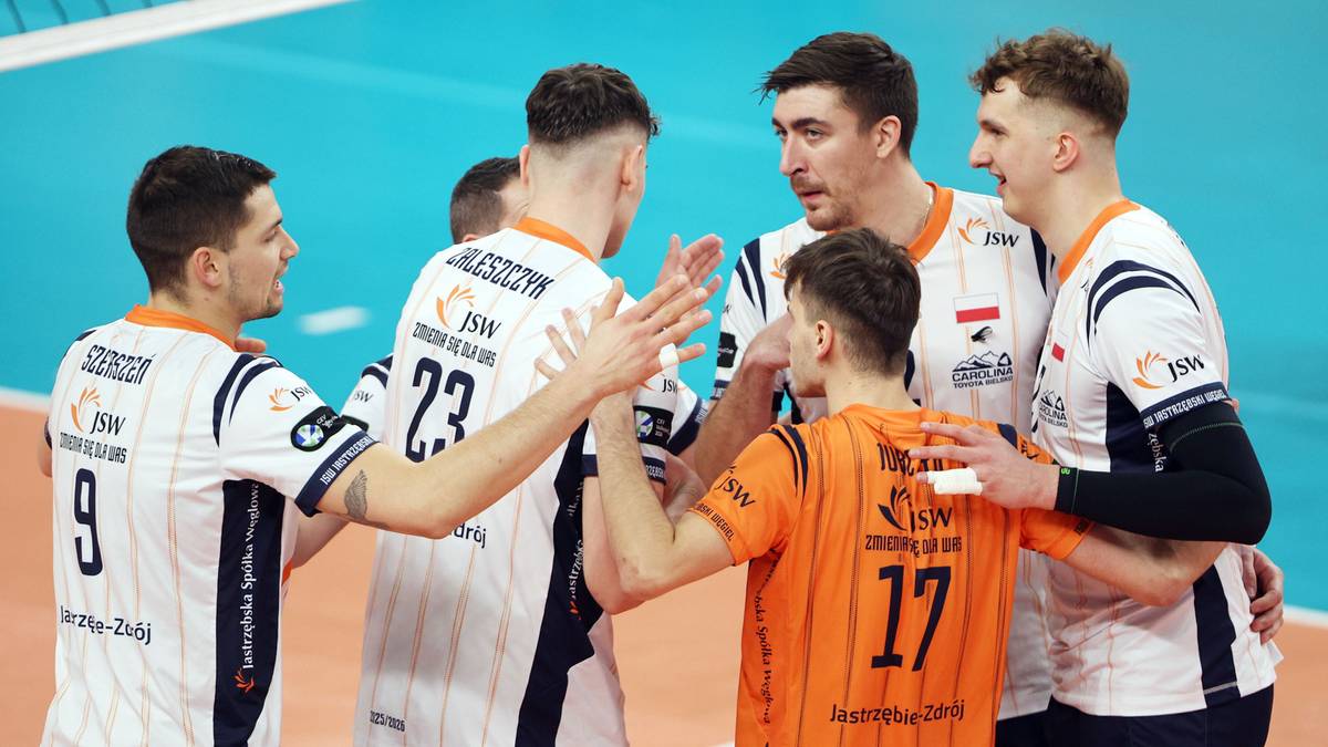 Grupa siatkarzy świętujących po wygranym meczu.