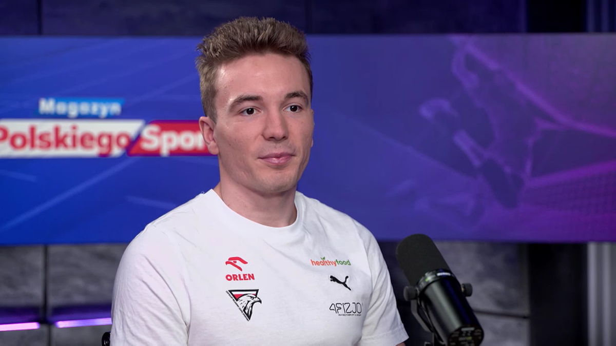 Jakub Szymański w studiu telewizyjnym, siedzi i rozmawia.