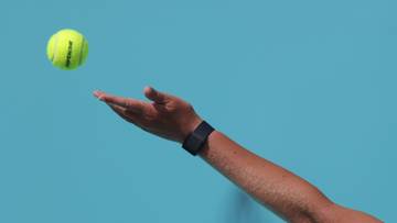 Tenisistka serwuje piłkę do tenisa.