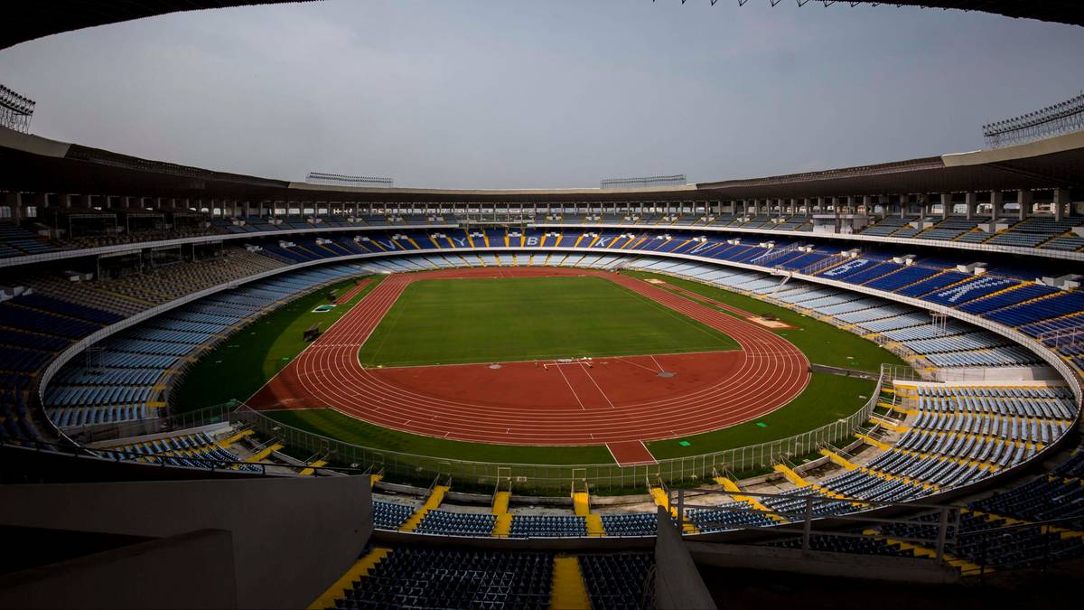 Widok na pusty stadion sportowy z bieżnią i trybunami.