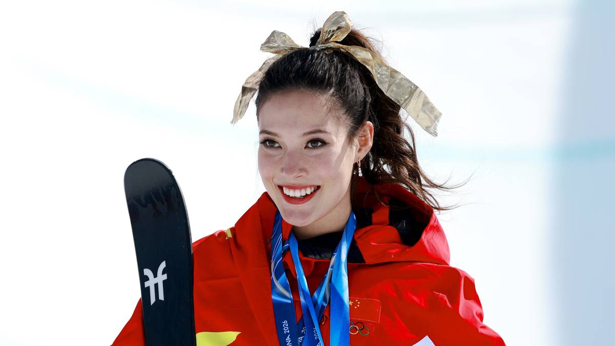 Narty, medale olimpijskie i uśmiechnięta narciarka dowolna w stroju sportowym.