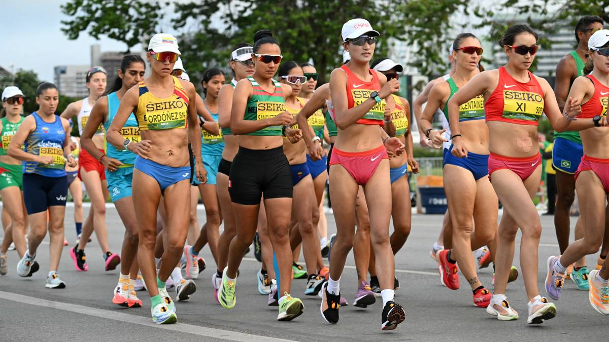 Grupa sportsmenek w strojach sportowych podczas zawod&oacute;w lekkoatletycznych.