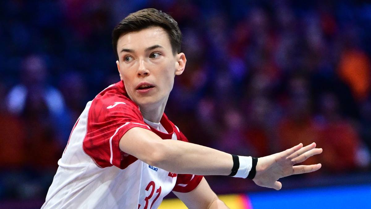 Zawodniczka reprezentacji Polski w piłce ręcznej z piłką w dłoni, w białej koszulce z czerwonymi akcentami.