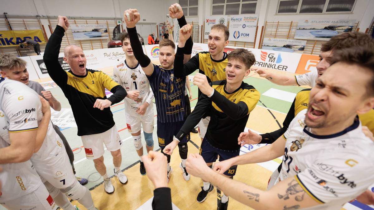 Grupa mężczyzn w strojach sportowych, świętująca zwycięstwo.