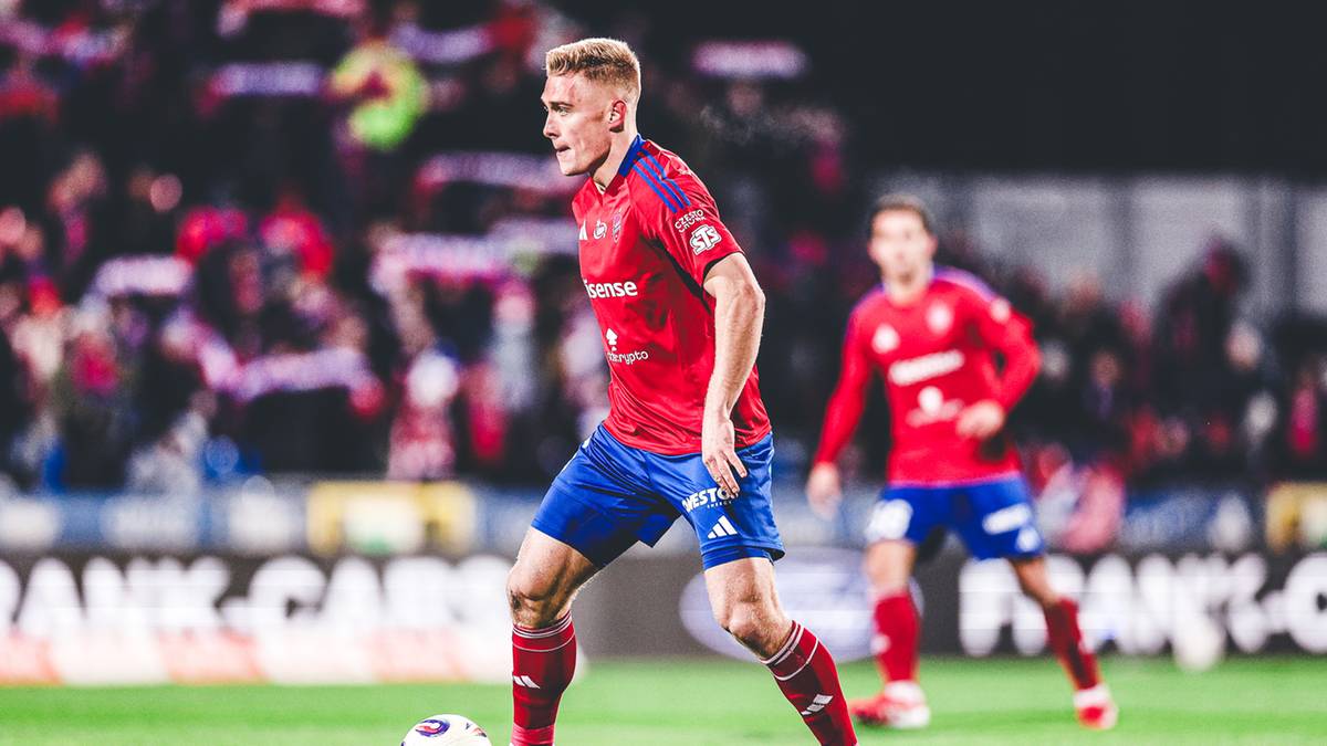 Piłkarz Rakowa Częstochowa prowadzi piłkę na boisku.