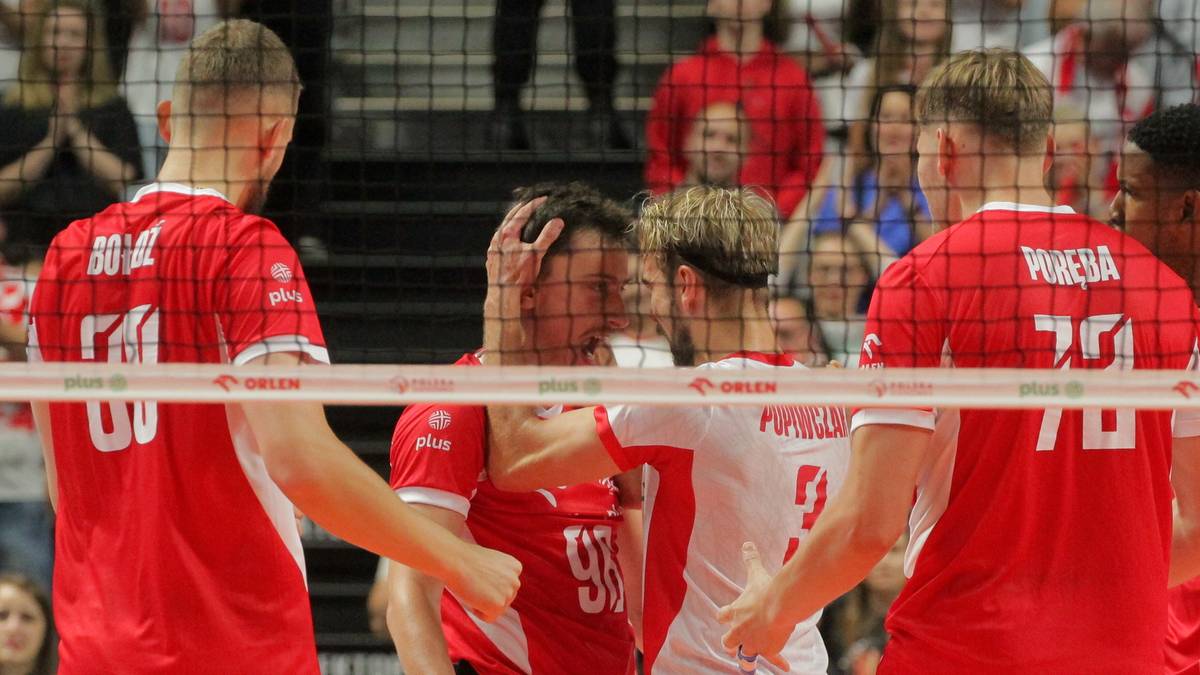 Siatkarze w czerwonych koszulkach reprezentacji Polski podczas meczu, jeden z zawodnik&oacute;w trzyma się za głowę.