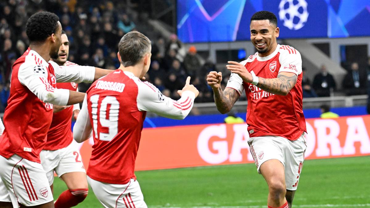 Piłkarze w czerwonych koszulkach świętują zdobycie bramki na boisku piłkarskim.