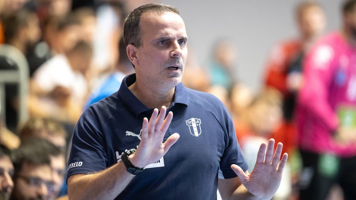 Trener piłki ręcznej ORLEN Wisły Płock zdeterminowany, z uniesionymi dłońmi, podczas meczu Ligi Mistrzów.