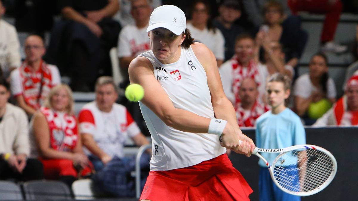 Iga Świątek serwuje podczas meczu tenisowego.