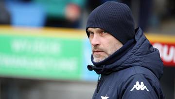 Mężczyzna w czapce i kurtce sportowej z logo.