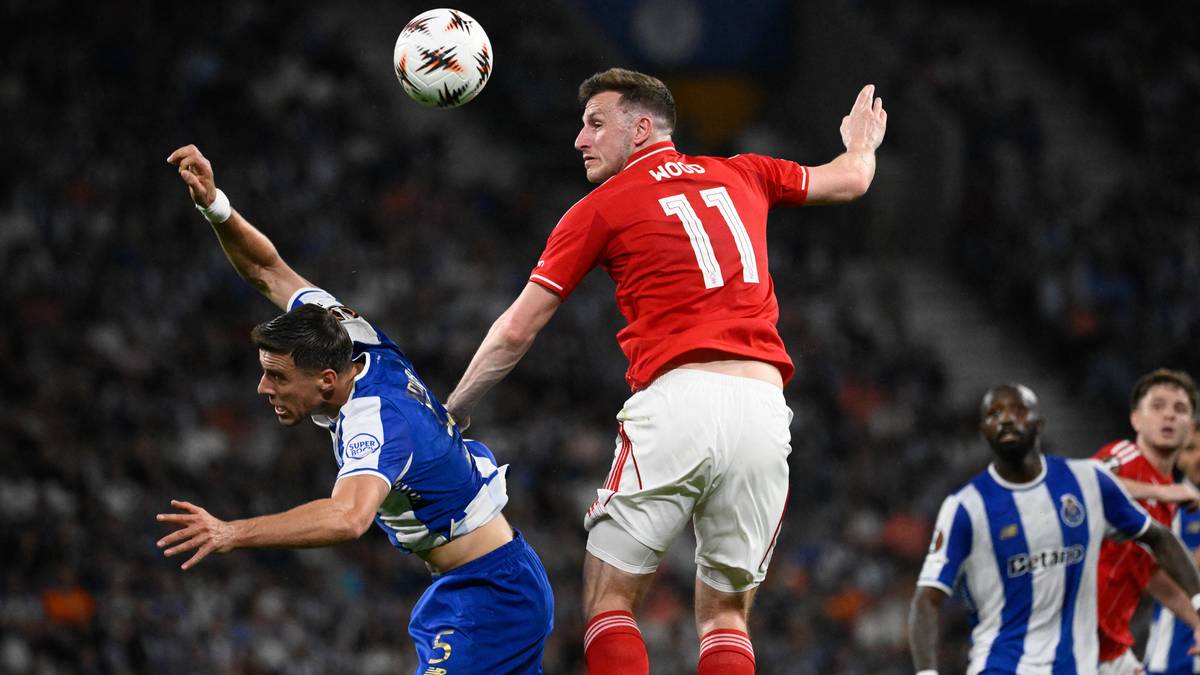 Dw&oacute;ch piłkarzy walczy o piłkę w powietrzu podczas meczu piłki nożnej.