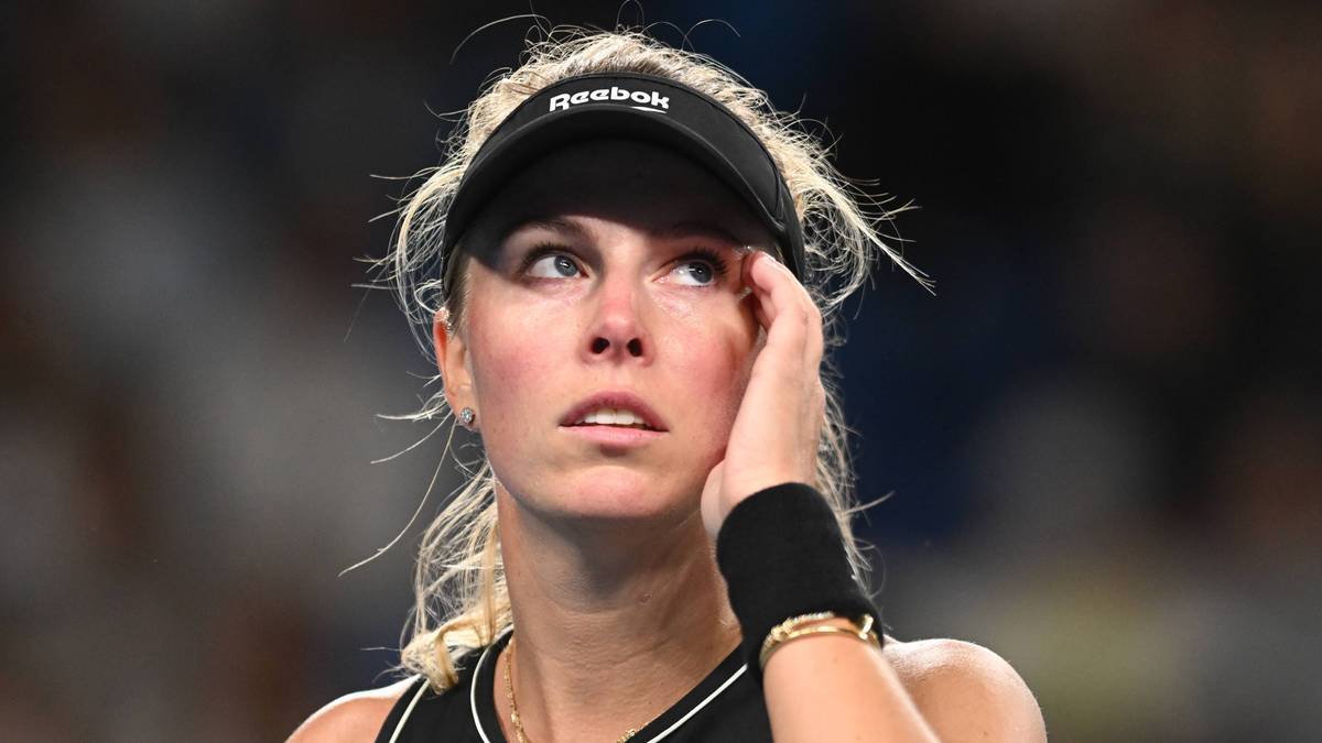 Portret tenisistki Magdaleny Fręch w czapce z daszkiem i opaską na nadgarstku, z dłonią na czole.