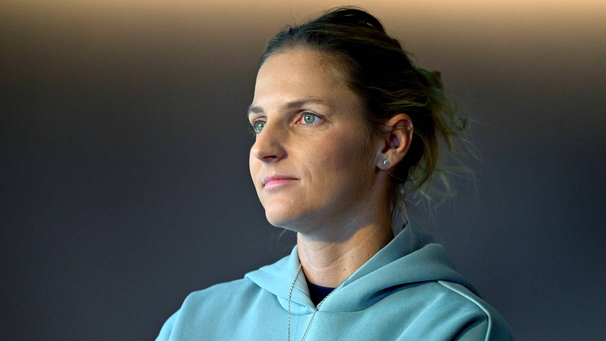 Karolina Pliskova w jasnoniebieskiej bluzie z kapturem, patrząca w bok z zamyślonym wyrazem twarzy.