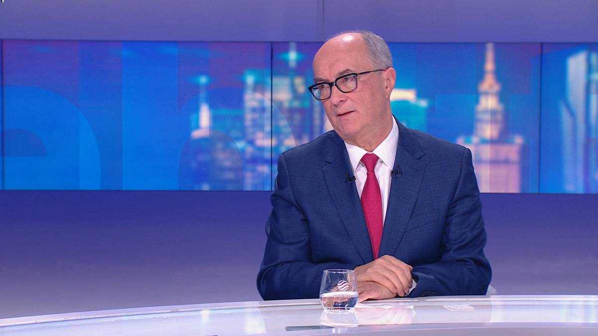 Włodzimierz Czarzasty siedzi w studiu telewizyjnym z założonymi rękami i szklanką wody przed sobą.