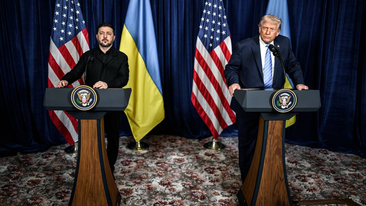 Wołodymyr Zełenski i Donald Trump stojący za m&oacute;wnicami z flagami Ukrainy i USA w tle.