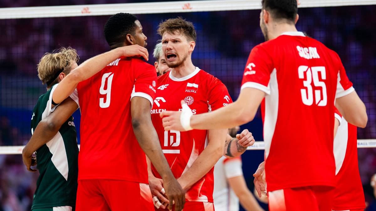 Pięciu graczy siatkówki w czerwonych koszulkach, stojących blisko siebie i dyskutujących, z numerami 9, 17, 35 na plecach. Dwóch z nich trzyma się za ramiona.