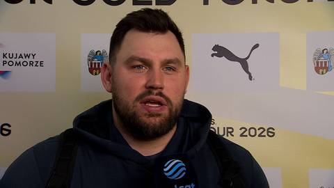 Konrad Bukowiecki, polski lekkoatleta, podczas wywiadu. Ma na sobie ciemną bluzę z kapturem. W tle widoczne są logotypy sponsor&oacute;w, w tym PUMA.