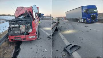 Uszkodzona czerwona laweta i niebieska ciężar&oacute;wka po wypadku na autostradzie A1.