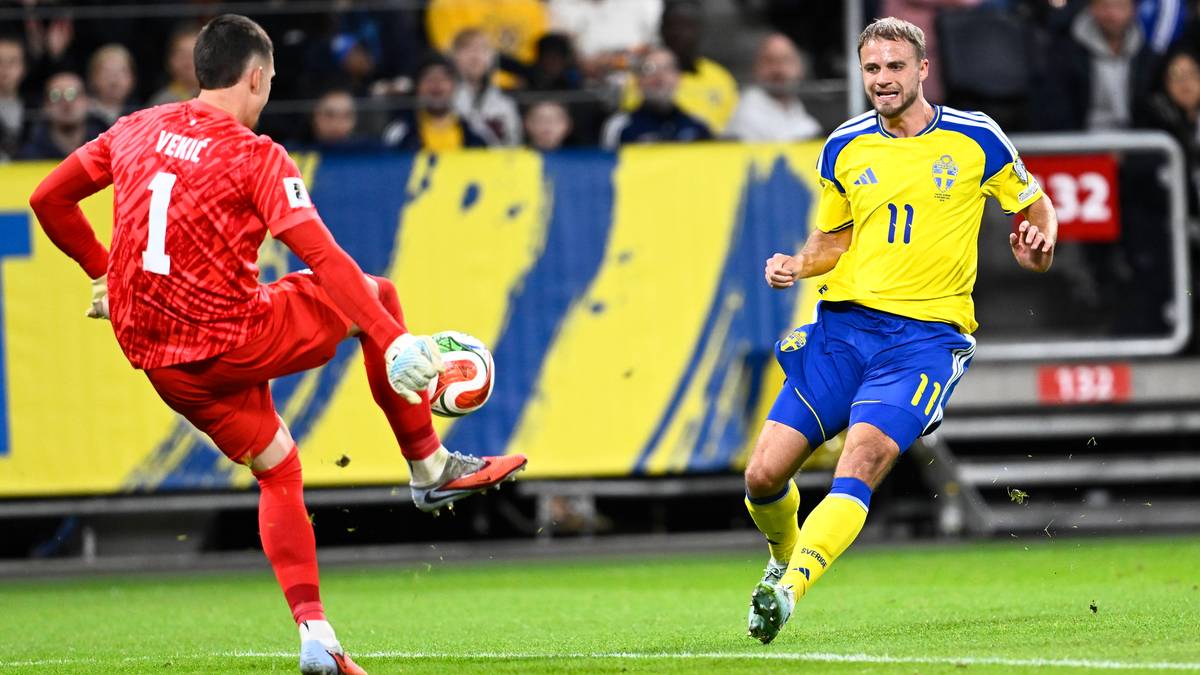 Dw&oacute;ch piłkarzy podczas meczu piłki nożnej, jeden z nich pr&oacute;buje strzelić gola.