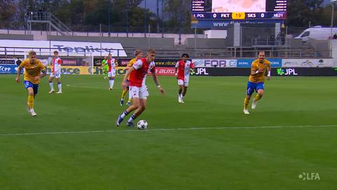 Piłkarz w czerwono-białym stroju prowadzi piłkę na boisku podczas meczu FK Teplice - Slavia Praga, w otoczeniu zawodnik&oacute;w drużyny przeciwnej w ż&oacute;łto-niebieskich koszulkach.