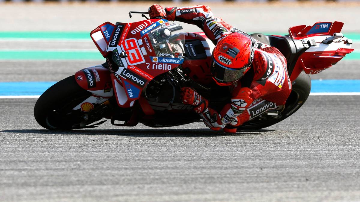 Motocyklista w czerwonym stroju na torze wyścigowym podczas zmagania na motocyklu