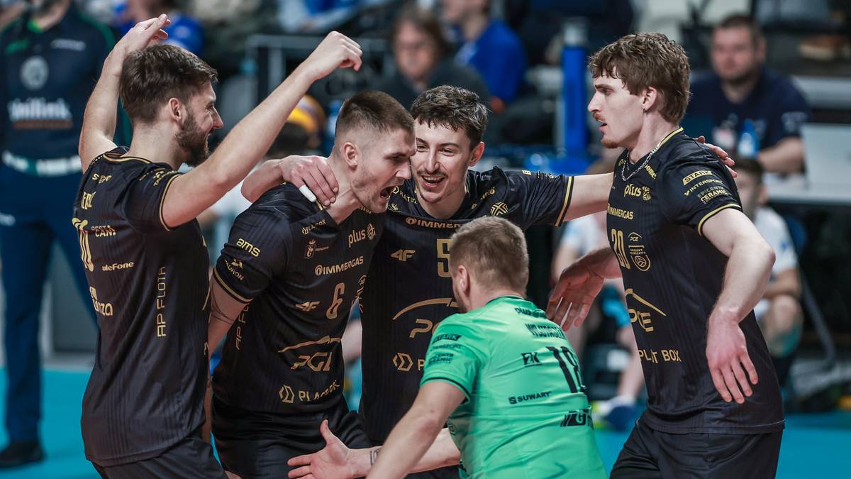 Grupa siatkarzy w czarnych strojach celebruje zdobyty punkt.