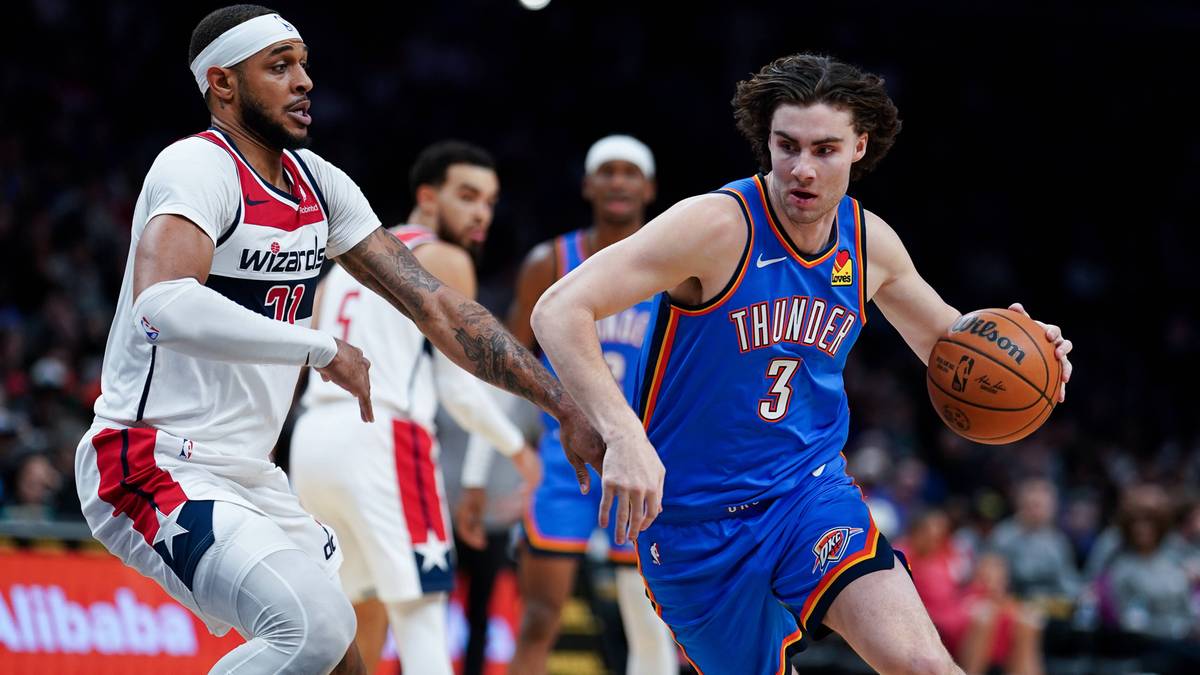 Dwóch koszykarzy podczas meczu NBA, jeden z piłką w niebieskim stroju, drugi w białym próbujący go zatrzymać.