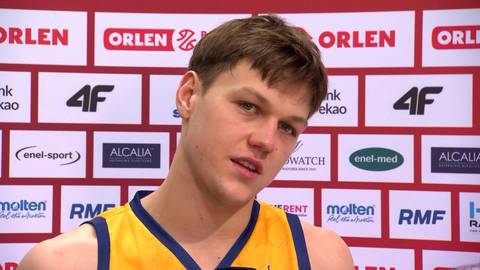 Filip Kowalczyk w ż&oacute;łtej kamizelce sportowej na tle ścian z logotypami Orlen i 4F.