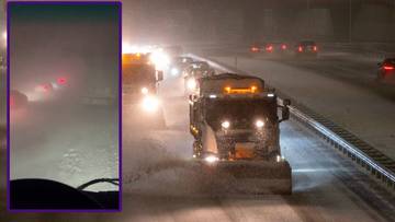 Samochody jadące w warunkach intensywnych opad&oacute;w śniegu i zawiei na drodze ekspresowej S7. Widoczne są pługopiaskarki usuwające śnieg z jezdni.