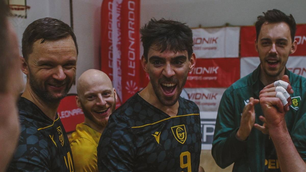 Grupa mężczyzn w strojach sportowych celebruje zwycięstwo, jeden z nich ma na koszulce numer 9.