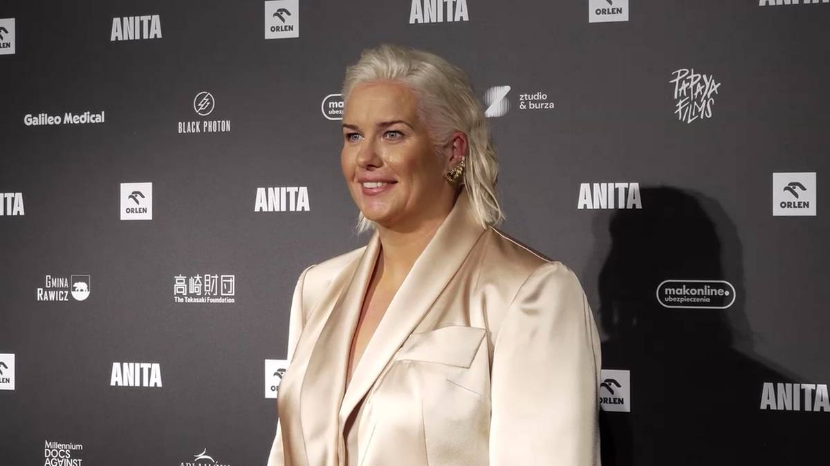 Anita Włodarczyk pozuje do zdjęcia na tle ściany z jej nazwiskiem.