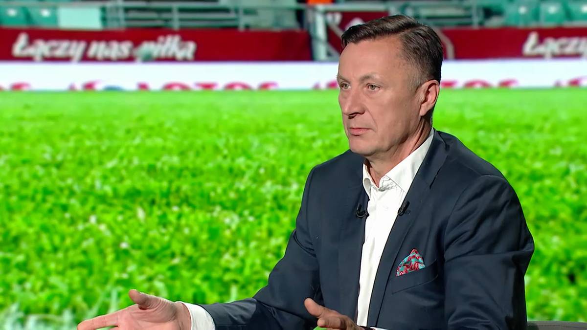 Portret Tomasza Hajto w studiu telewizyjnym przed boiskiem.