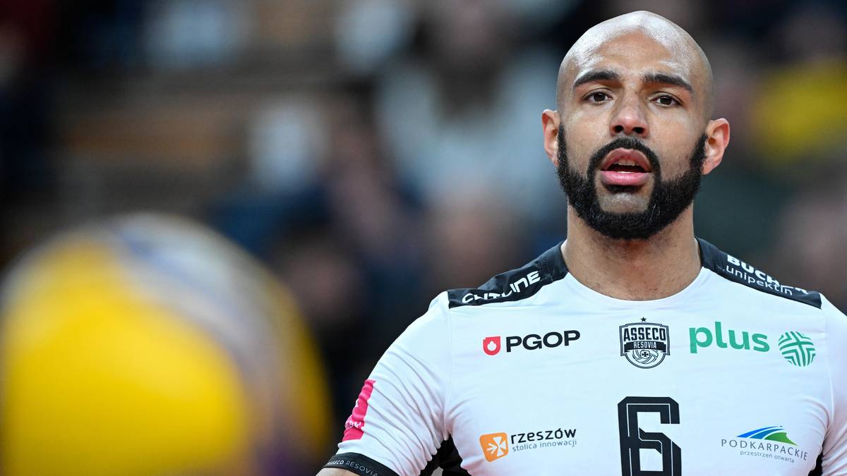 Portret siatkarza Danny'ego Demyanenko w koszulce Asseco Resovii Rzesz&oacute;w, widoczny z profilu, z rozmytą piłką siatkową w tle.