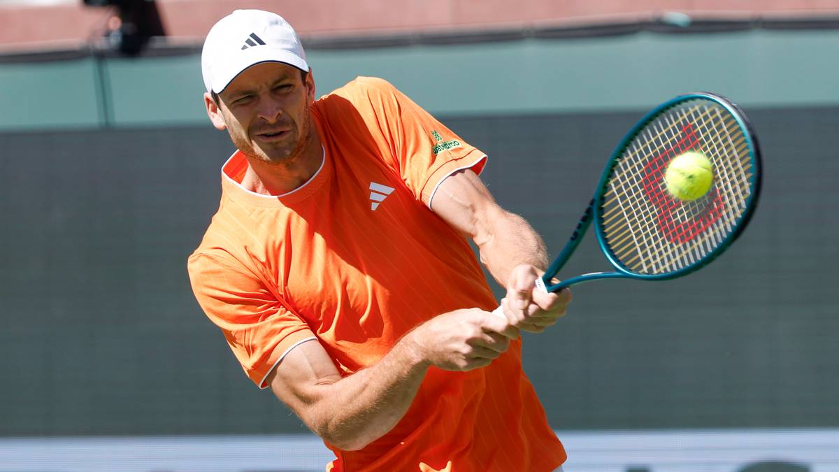 Tenisista Hubert Hurkacz w akcji, odbijający piłkę rakietą podczas meczu.