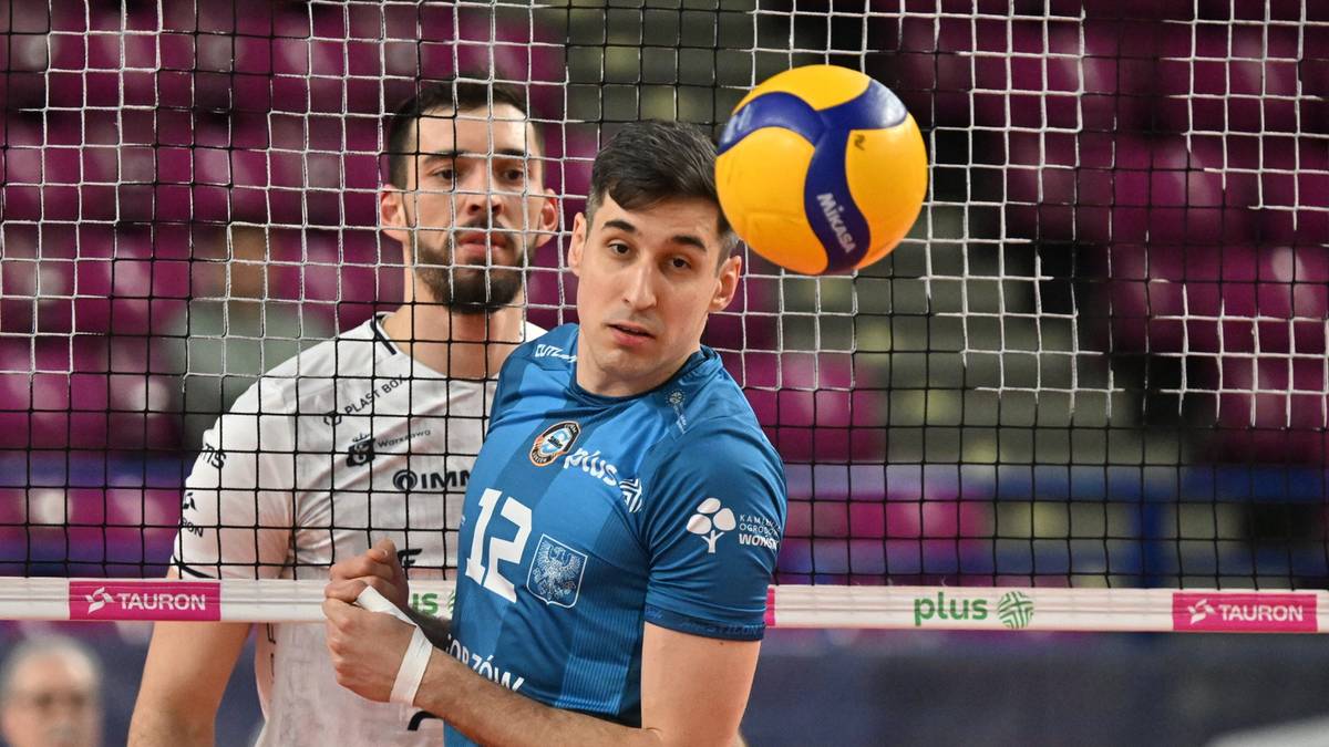 Dwóch siatkarzy podczas akcji meczowej, jeden z nich odbija piłkę nad siatką.