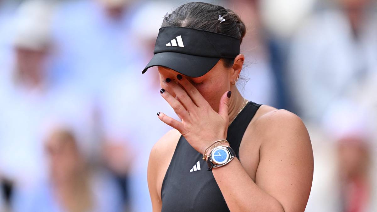 Kobieta w czarnej czapce z daszkiem i czarnym topie sportowym zakrywa twarz dłonią, jej oczy są zamknięte.