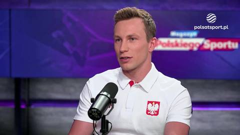 Łukasz Gutkowski w białej koszulce z godłem Polski przed mikrofonem, w tle napis "Polskiego Sportu".