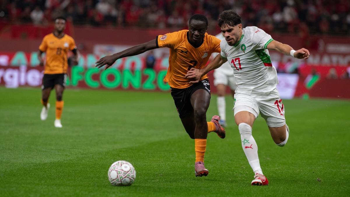 Dw&oacute;ch piłkarzy walczących o piłkę na boisku podczas meczu.