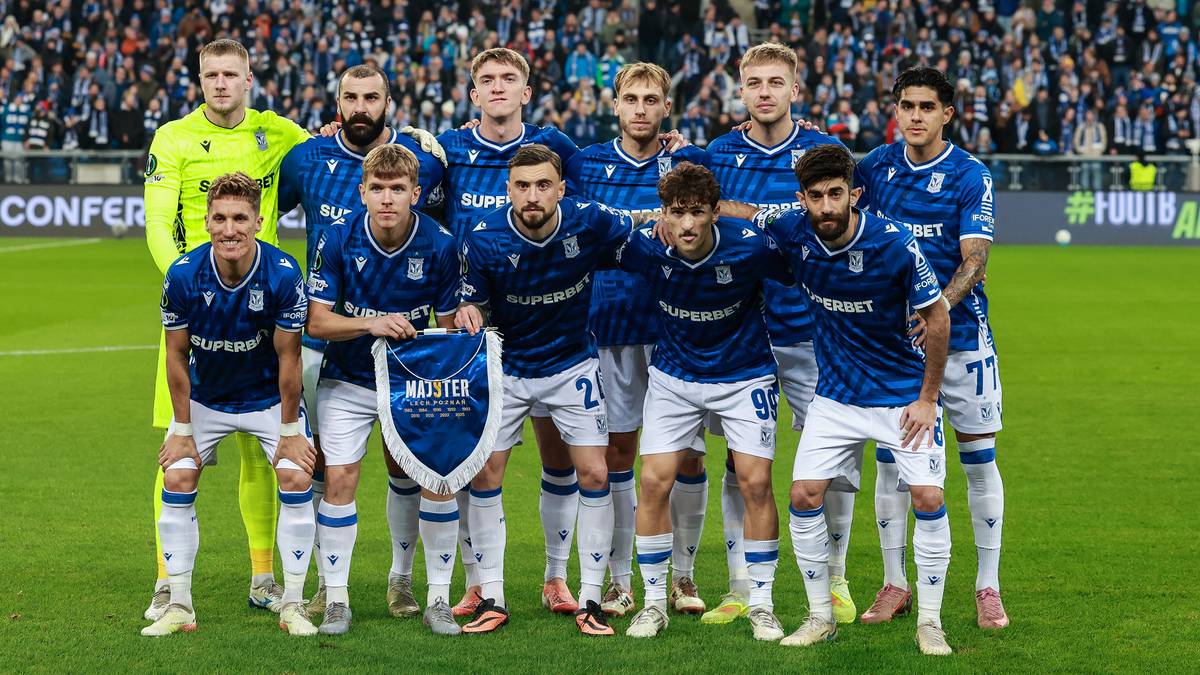 Drużyna piłkarska Lecha Poznań pozuje do zdjęcia na murawie stadionu.
