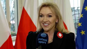 Agnieszka Gloria Kamińska z mikrofonem Polsat Sport, w tle flagi Polski i Unii Europejskiej.