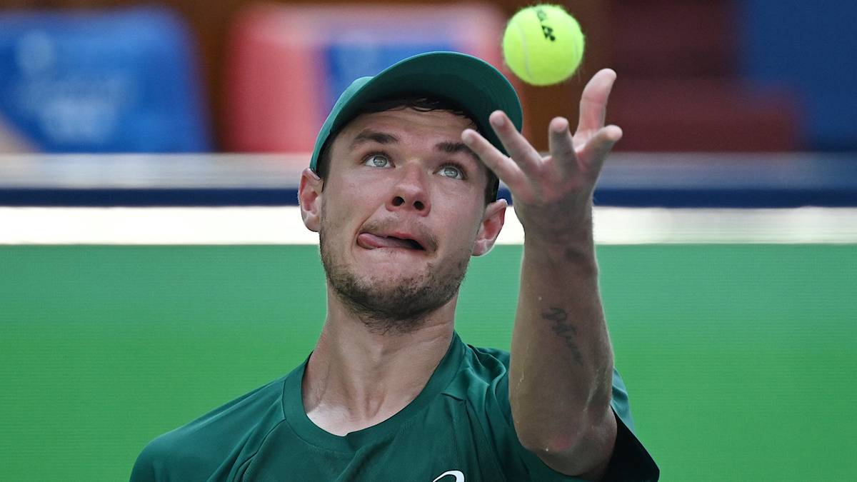 Tenisista Kamil Majchrzak rzuca piłkę tenisową przed zagraniem.