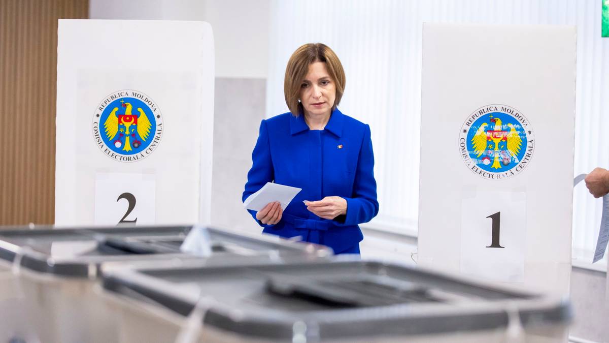 Prezydent Mołdawii Maia Sandu w ambasadzie podczas głosowania, trzyma kartę do głosowania i długopis.