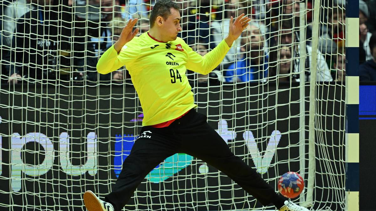 Bramkarz piłki ręcznej w żółtej koszulce z numerem 94 broni bramki.