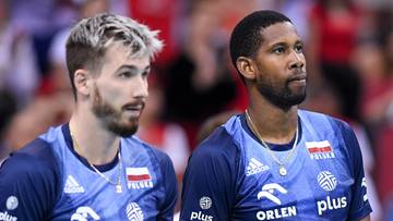 Dw&oacute;ch siatkarzy w niebieskich koszulkach reprezentacji Polski trzyma piłki siatkowe.