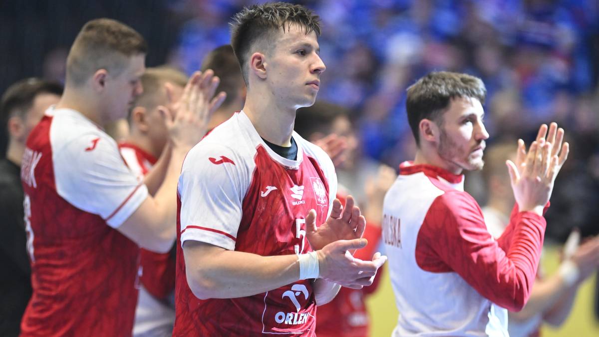 Grupa zawodnik&oacute;w reprezentacji Polski w piłce ręcznej klaszcze podczas meczu lub po jego zakończeniu.