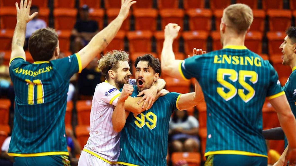 Czterech siatkarzy w zielonych strojach świętuje zdobycie punktu.