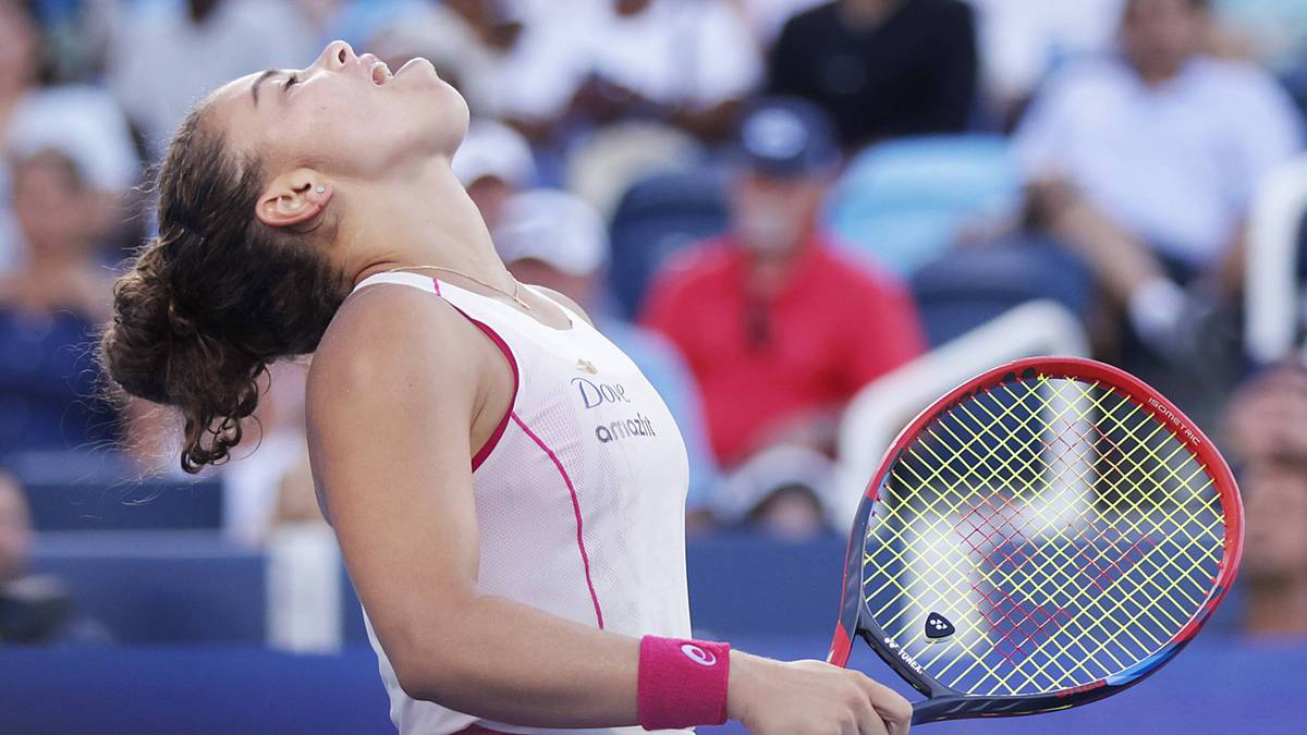 Kobieta tenisistka z opuszczoną głową i zamkniętymi oczami, trzymająca rakietę tenisową, wyraz twarzy sugeruje rozczarowanie po przegranym meczu.