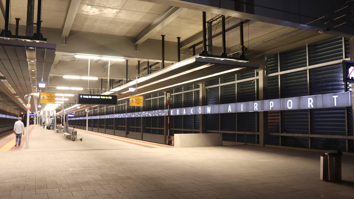 Pusta peron kolejowy z tablicą informacyjną z napisem "AIRPORT"