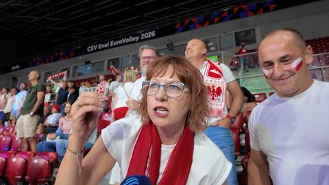 Grupa polskich kibic&oacute;w na trybunach hali sportowej, w pierwszym planie kobieta w okularach i czerwonym szaliku oraz mężczyzna z wymalowanymi polskimi flagami na policzkach.
